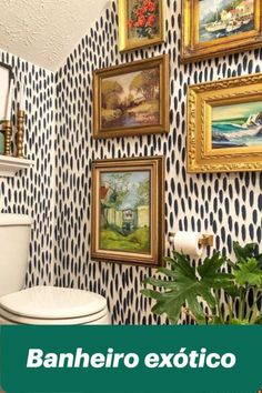 a white toilet sitting in a bathroom next to a potted plant and pictures on the wall