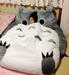 a child is laying in a bed with an animal pillow