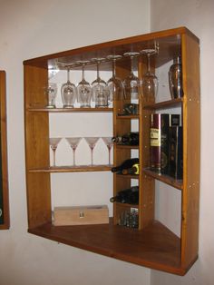 a wooden shelf filled with wine glasses and bottles