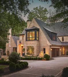 a large brick house with lots of windows and lights on it's front door