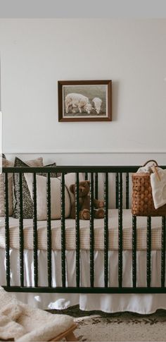 a baby's crib in the corner of a room with pictures on the wall