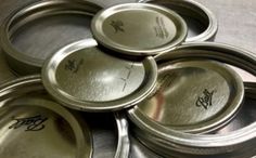 six metal pans with writing on them sitting on a table