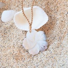 Embrace the essence of the ocean with our Moana Mother of Pearl Necklace, inspired by the Hawaiian word "moana," meaning "ocean." This exquisite necklace features a beautifully carved mother of pearl shell in the shape of a tropical flower, symbolizing the grace and beauty of the sea. The pendant is affixed to a twisted hemp rope, adding a touch of natural charm to the design. The adjustable rope necklace, secured with a bead, ensures a perfect fit for any occasion. Whether you're channeling your inner mermaid or simply adding a touch of island elegance to your outfit, the Moana Mother of Pearl Necklace is a timeless piece that celebrates the tranquility and allure of the ocean. Material: mother-of-pearl shell Pendant: ~ 2" Adjustable Length Hand carved, each unique Jewelry pouch included Beach Flower Pendant Necklace, White Spiritual Shell Necklace, Spiritual White Shell Necklace Gift, White Spiritual Shell Necklace As A Gift, White Mother Of Pearl Pendant Shell Necklace, White Flower Charm Necklace For Beach, White Flower Charm Necklace For The Beach, White Flower Pendant Jewelry For Beach, Elegant Flower Necklace For Beach