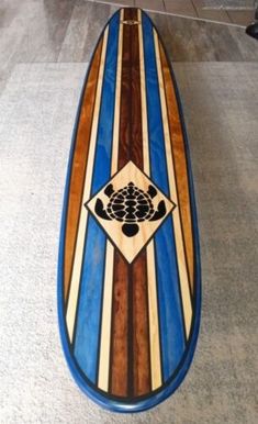 a wooden surfboard sitting on top of a tile floor