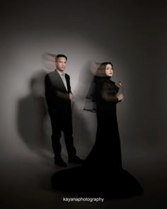 a man and woman standing in front of a wall