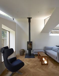 a living room filled with furniture and a wood burning stove in the middle of it