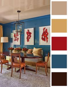 a dining room with blue walls and red art hanging on the wall above the table