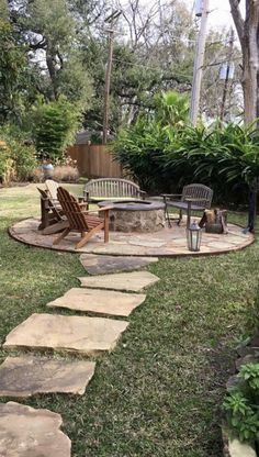 an outdoor patio with stone steps leading up to a fire pit and seating area in the back yard