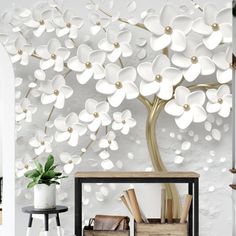 a living room with white flowers on the wall and a large tree behind it,