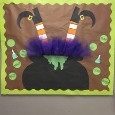 a bulletin board decorated with purple and green decorations on it's sides, including witch hats