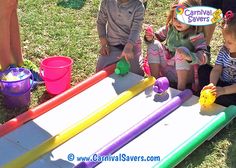 three children playing with toys in the grass