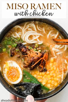 someone holding a bowl of miso ramen with chicken