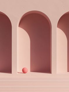 an orange ball sitting on top of a shelf in the middle of some pink walls