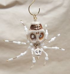 a white and brown spider ornament hanging from a hook