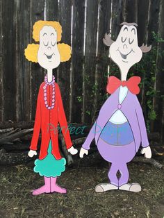 two paper cut outs of cartoon characters standing next to each other in front of a fence