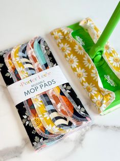 a mop pad and cleaning brush sitting on top of a marble counter next to each other