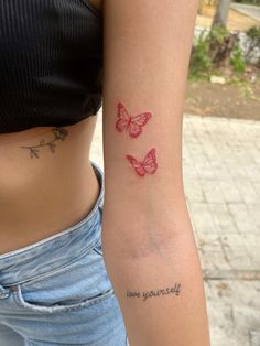 a woman with a tattoo on her left arm and two butterflies on her right arm