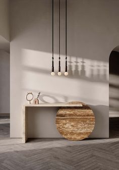 a wooden table sitting in the middle of a room next to a wall mounted light fixture