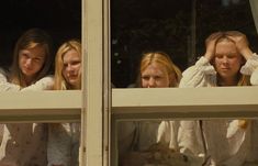 three girls looking out the window at something