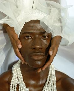 a man with white hair and pearls on his head