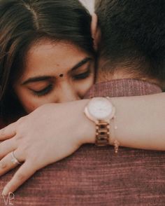 a man and woman embracing each other with their hands on the back of his shoulder