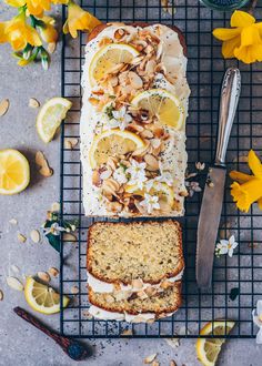 a loaf of lemon almond bread sitting on top of a cooling rack next to sliced lemons