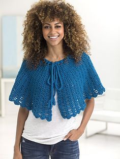 a woman with curly hair wearing a blue crochet shawl