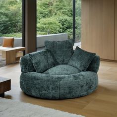 a living room filled with furniture next to a large glass window and wooden flooring