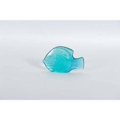 a blue glass fish sitting on top of a white table