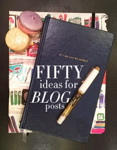 a book and pen sitting on top of a table next to each other, with the title fifty ideas for blog posts written in it