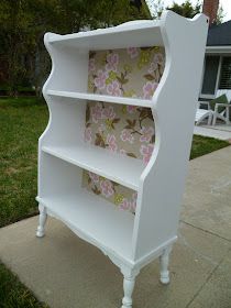 a white book shelf sitting on top of a sidewalk