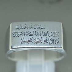 "This empower sterling silver ring had engraved the Third Kalima Tamjeed \"subhanallah walhamdulillah wala ilaha illallah wallahu akbar wala hawla wala quwwata illa billah aliyyil azeem\": سُبْحَان اللهِ وَالْحَمْدُلِلّهِ وَلا إِلهَ إِلّااللّهُ وَاللّهُ أكْبَرُ وَلا حَوْلَ وَلاَ قُوَّةَ إِلَّا بِاللّهِ الْعَلِيِّ الْعَظِيْم \"Glory be to Allah and all praise be to Allah, there is none worthy of worship except Allah, and Allah is the Greatest. There is no might or power except from Allah, the Exa Spiritual White Gold Engraved Ring With Polished Finish, Spiritual Silver Signet Ring For Wedding, Engraved White Gold Spiritual Signet Ring, Engraved White Gold Signet Ring With Spiritual Style, Traditional Hallmarked White Gold Signet Ring, Traditional Silver Hallmarked Signet Ring, Traditional White Gold Sterling Silver Signet Ring, Traditional Silver Signet Ring For Anniversary, Traditional White Gold Signet Ring For Anniversary