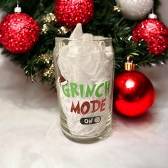 a glass filled with ice next to christmas ornaments and a red bauble ornament