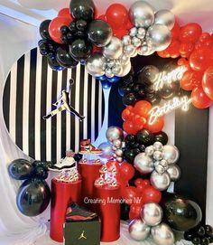 the balloon arch is decorated with black, white and red balloons