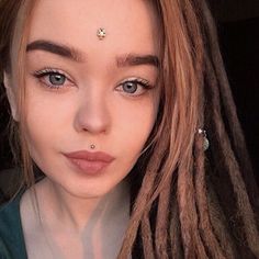 a woman with dreadlocks is taking a selfie