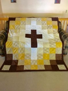 a couch that has a blanket on it with a cross on it in the middle