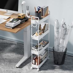 a computer desk with books, papers and pens on it next to a vase filled with pencils