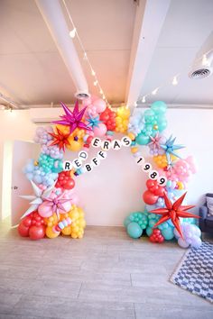 an arch with balloons and starfishs on it in the middle of a room