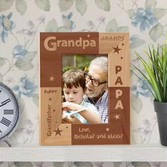 an old photo frame with the words grandpa on it next to a potted plant