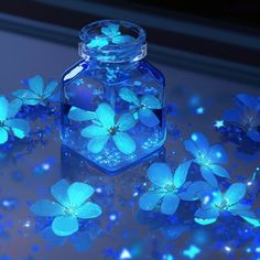 blue flowers are floating in a glass jar on a surface with light shining through it