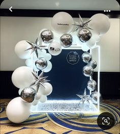 a mirror frame with balloons and starfishs on it in the middle of a room