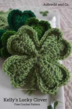 three crocheted clovers sitting on top of a white plate