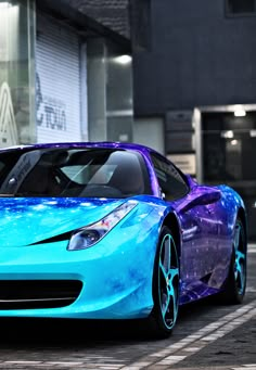 a blue and purple sports car parked in front of a building