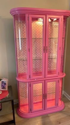 a pink china cabinet with lots of glass doors