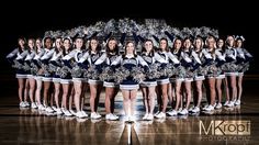 a group of cheerleaders standing on top of a basketball court