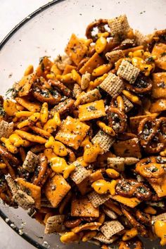 a glass bowl filled with cheesy crackers and seasoning sprinkled on top