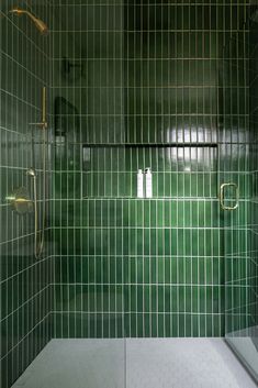 a green tiled bathroom with shower and toilet