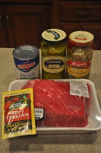 raw meat, pickles, mustard and spices on a counter top next to canned food