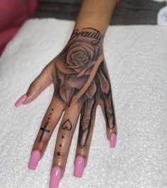 a woman's hand with a rose tattooed on it