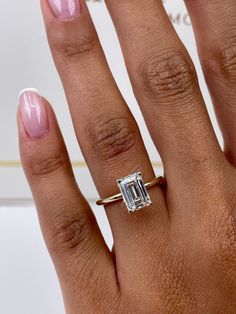 ✥ Elevate your love story to timeless elegance and ethical consciousness with our exquisite 1.79-carat emerald-cut F-color, VS-clarity lab-grown diamond engagement ring in a classic solitaire style. This ring is more than just a symbol of commitment; it's a testament to your dedication to a sustainable future. The emerald-cut diamond, renowned for its captivating elegance and distinctive step-cut facets, takes center stage, radiating with a mesmerizing sparkle and exceptional clarity that mirror the depth of your connection. The solitaire setting adds an understated sophistication, allowing the diamond's natural beauty to shine without distraction. Crafted with meticulous precision and a strong commitment to eco-conscious practices, this ring transcends mere jewelry; it's a representation Emerald Cut Small Engagement Ring, Emerald Lab Grown Engagement Ring, Emerald Engagement Ring Yellow Gold, Engagement Rings Emerald Cut Gold, White Gold Emerald Cut Engagement Ring, 2 Carat Emerald Engagement Rings, Emerald Engagement Ring Stack, Emerald Cut Engagement Ring With Band, Emerald Engagement Ring Gold